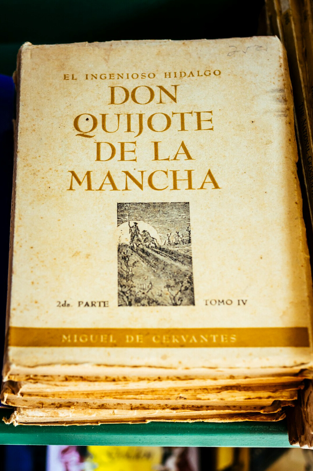 Pila de libros antiguos con una lupa encima sobre una mesa de madera