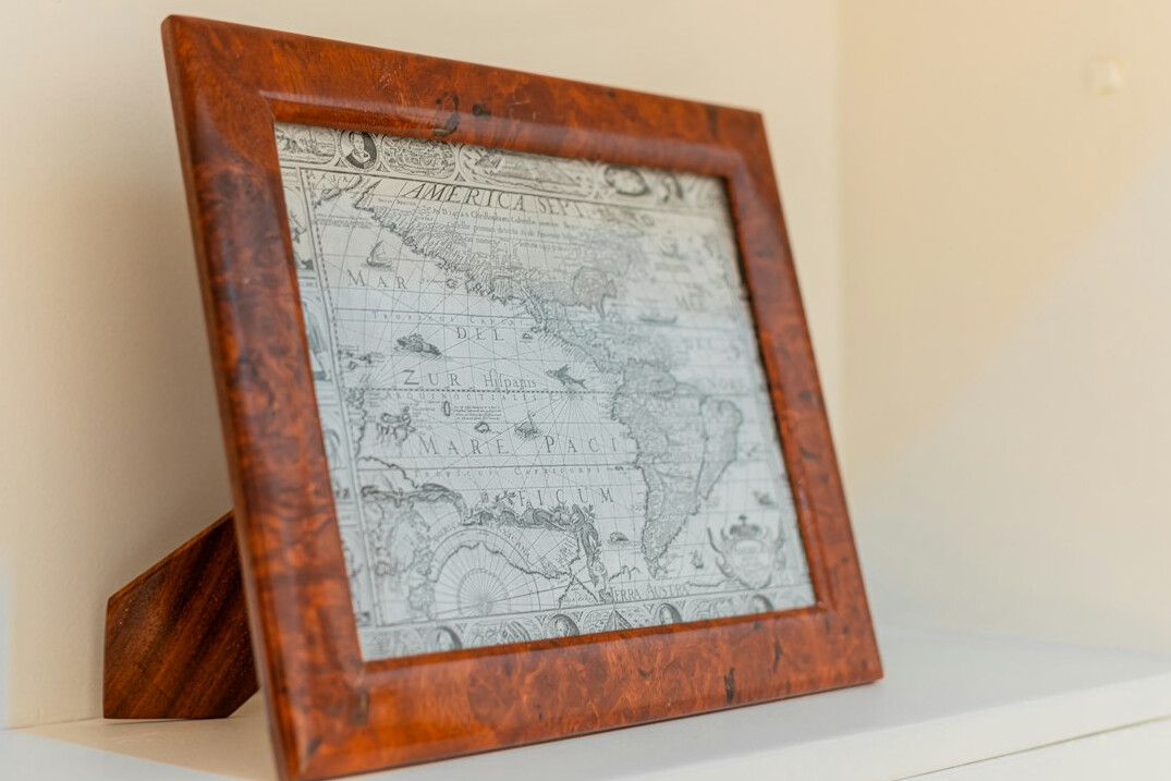 Lupa y mapa antiguo sobre un escritorio de madera con un cuaderno